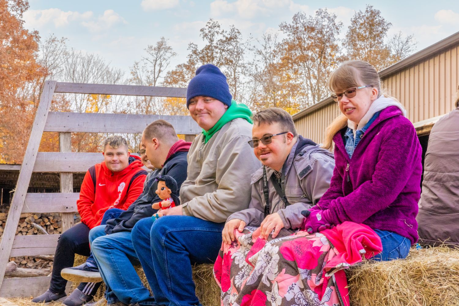 Group picture of people sitting on a hay stack